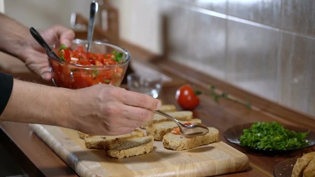 The person puts the ingredients on top of the bread for cooking bruschetta