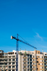 Fototapeta na wymiar Crane, building and blue sky.