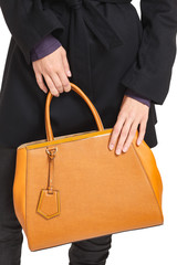 Girl holds a brown bag close-up on an isolated white background