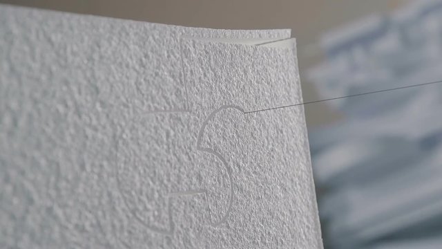 Close up: Cutting plastic foam. The process of creating volumetric figures of foam plastic. Cutting out volumetric letters of foam plastic. Figured cutting of foam plastic.