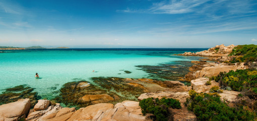 Wild beautiful rocky beach with turquoise transparent water and large stones in Vourvourou,...