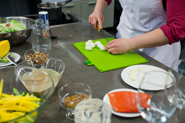 The chef prepares a salad with salmon