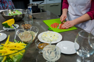 The chef prepares a salad with salmon