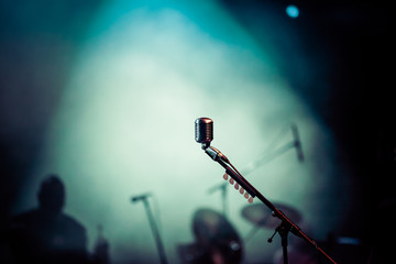 Fototapeta na wymiar microphone in stage lights during concert - summer music festival