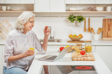 Joyful senior woman communicating in internet