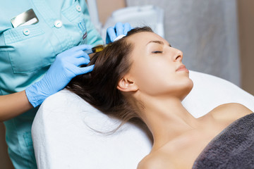 Needle mesotherapy. Cosmetic been injected in woman's head. Thrust to strengthen hair and their growth