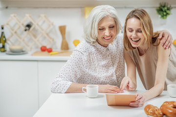 Cheerful women watching family photos