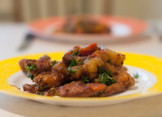 Meat with greenery on yellow plate