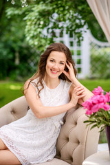 beautiful young girl with a gentle dress in a luxurious garden , portrait