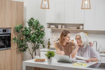 Carefree woman showing mom how computer works