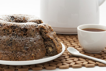 Chocolate cake with sugar decorated with caffe tea cups for tea weddings birthday breacks presented on white plate and decorated brown tablecloth