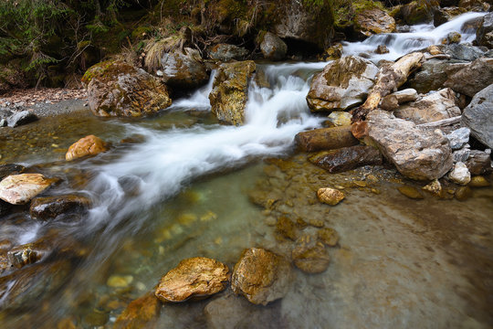 Stony mountain stream in Alpine hill. Rainy spring weather