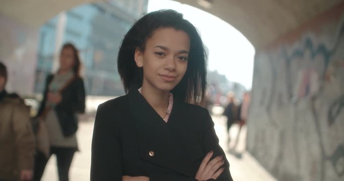 Portrait of young African American woman looking to a camera, outdoors.