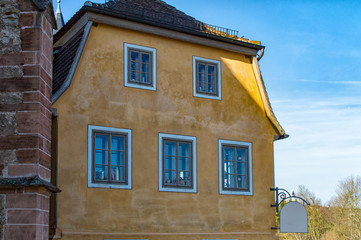 Obraz premium Old house with yellow facade and wooden windows