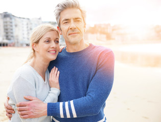 Middle-aged couple walking together on a sandy beach