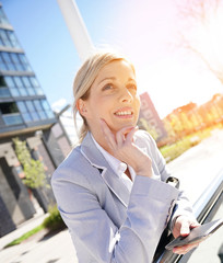 Portrait of smiling businesswoman standing outside