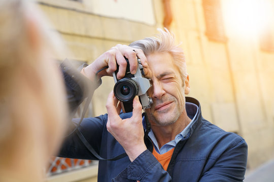 Man taking pictures of woman in old quarter street