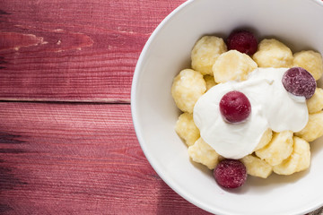 Traditional russian, ukrainian cottage cheese lazy dumplings served with sour cream and cherry