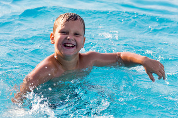 The boy is swimming in the pool