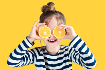 Girl with oranges on the background in the studio