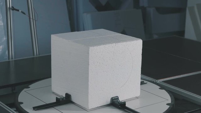 Cube of expanded polystyrene foam. Figured cutting of foam plastic. Volumetric form. Decor of foam plastic. Creation of volumetric scenery from foam plastic. Automatic machine for cutting from foam.