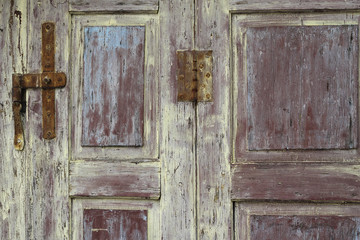 Red, yellow and blue coatings on a paling wooden door