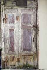 Fading colorful wooden door with rusty fittings