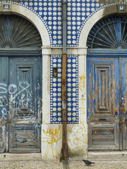 Characteristic but decaying doors and tiled facade in Lisbon, Portugal