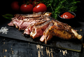 Steak with herbs and beer on a wooden background