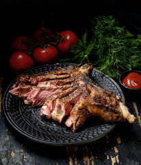 Steak with herbs and beer on a wooden background