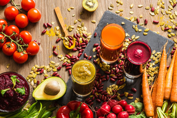 Healthy vegan food. Fresh vegetables on wooden background. Detox diet. Different colorful fresh juices