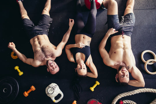 Top view of accessories for fitness and tree athlete lying on floor. Dumbbells, weight plates, kettles, rope, barbells. Concept for sport or workout.