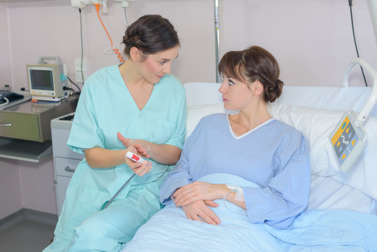 Nurse talking to patient in hospital bed