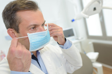Doctor putting on mask