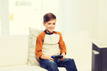 happy boy with joystick playing video game at home