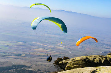 PRILEP, MACEDONIA - circa FEB, 2017: Three paraglider fly in summer sunny day