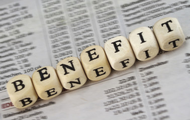 Benefit word built with letter cubes on newspaper background