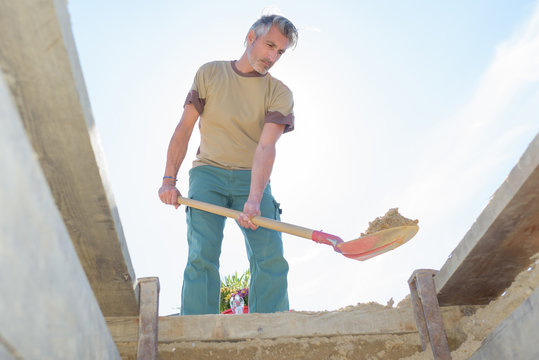 man using a spade to dig