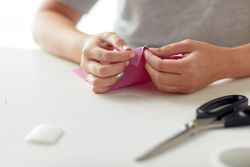 woman with needle stitching fabric pieces