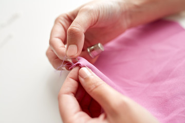 woman with needle stitching fabric pieces