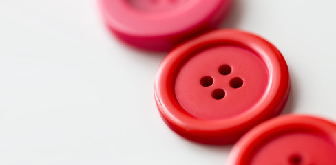 red and pink sewing buttons on white background
