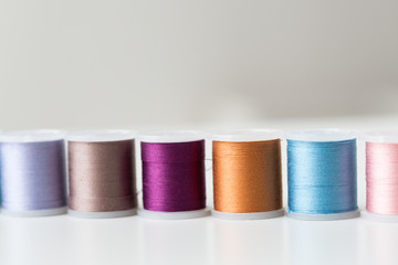 row of colorful thread spools on table