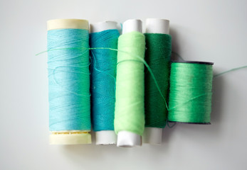 green and blue thread spools on table