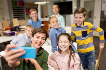 group of school kids taking selfie with smartphone