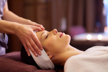 Fototapeta na wymiar woman having face and head massage at spa