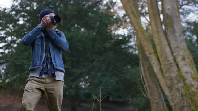 4K Photographer takes a photo as he enjoys the view in the forest