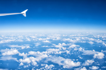 Fototapeta na wymiar sunny blue cloudy sky and plane wing