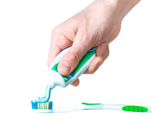 Toothpaste and a brush in a man's hand isolated on white