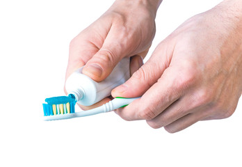 Toothpaste and a brush in a man's hand isolated on white