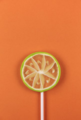 lime lollipop on an orange background